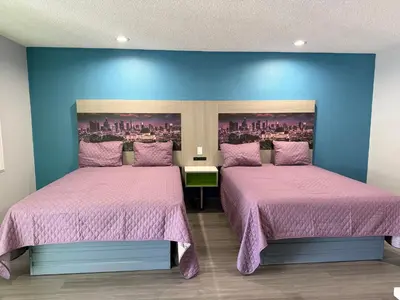 two beds in a room with pink bedspreads at Hi-Way Host Motel in Pasadena