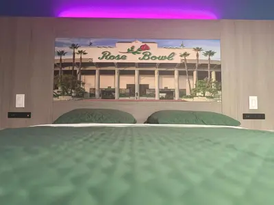 a bedroom with a large bed in front of a hotel at Hi-Way Host Motel in Pasadena