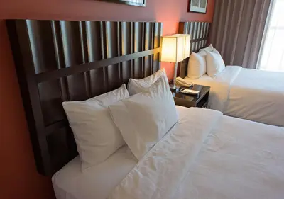 a hotel room with two beds with white pillows at Embassy Suites Ontario - Airport in Ontario