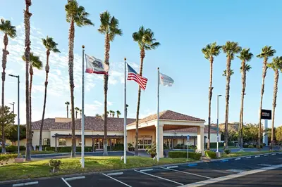 a hotel with palm trees in front of a street at Hilton Garden Inn Valencia Six Flags in Valencia