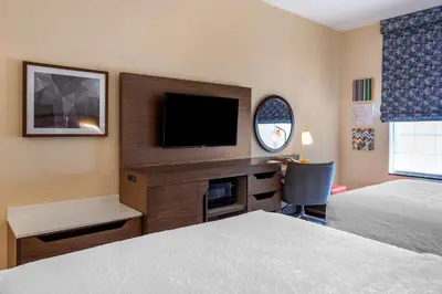 a hotel room with two beds and a flat screen tv at Hampton Inn Norco/Corona in Norco