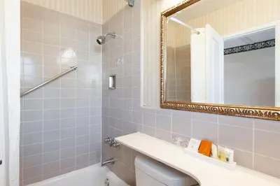 a bathroom with a tub and a sink and a mirror at Studio City Court Yard Hotel in Los Angeles