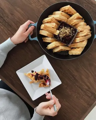 a person holding a fork and a plate of food at Hyatt Place Glendale/Los Angeles in Glendale
