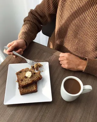 a person sitting at a table with a plate of cake and coffee at Hyatt Place Glendale/Los Angeles in Glendale