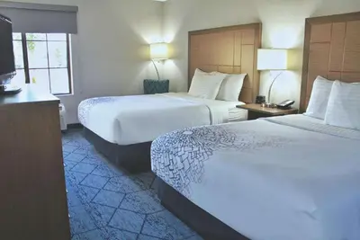 a hotel room with two beds and a television at La Quinta by Wyndham NE Long Beach/Cypress in Hawaiian Gardens