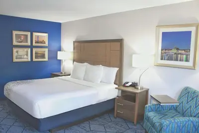 a hotel room with a bed and a chair at La Quinta by Wyndham NE Long Beach/Cypress in Hawaiian Gardens