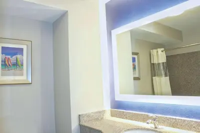a bathroom with a sink and a mirror at La Quinta by Wyndham NE Long Beach/Cypress in Hawaiian Gardens