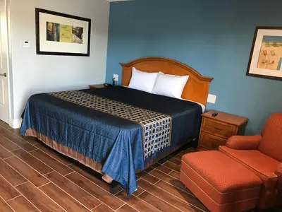 a hotel room with a bed and a chair at Driftwood Motel in Torrance