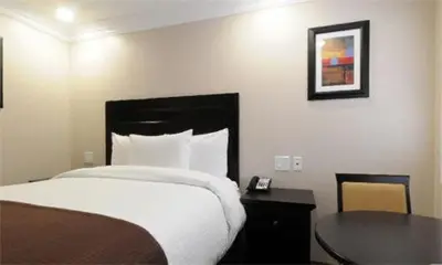 a hotel room with a bed and a table with a table at Raincross Hotel Riverside in Riverside
