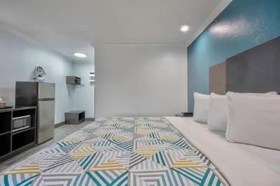 a large bed in a room with a kitchen at Studio 6 Suites San Bernardino, CA in San Bernardino