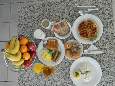 a table topped with plates of breakfast foods and drinks at California Inn Barstow in Barstow