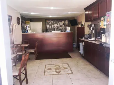 a restaurant with a bar and a table and chairs at Super 8 by Wyndham Redlands/San Bernardino in Redlands