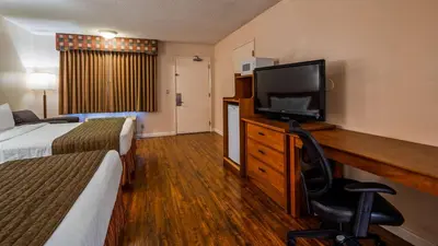 a hotel room with two beds and a flat screen tv at SureStay Hotel by Best Western Tehachapi in Tehachapi