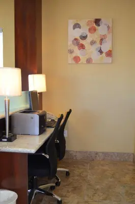 a office with a desk with two chairs and a printer at SureStay Hotel by Best Western Tehachapi in Tehachapi