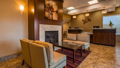a lobby with a fireplace and a table and chairs at SureStay Hotel by Best Western Tehachapi in Tehachapi
