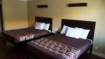 a hotel room with two beds and a phone at Anaheim Astoria Inn & Suites in Anaheim