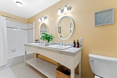 a bathroom with a sink and a toilet and a mirror at Channel Road Inn, A Four Sisters Inn in Los Angeles