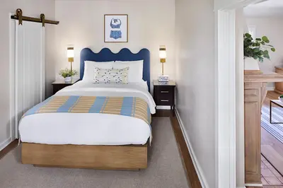 a bedroom with a bed with a blue headboard at Channel Road Inn, A Four Sisters Inn in Los Angeles