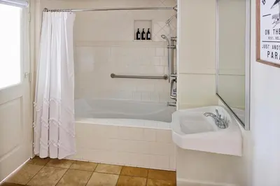 a white bathroom with a tub and a sink at Channel Road Inn, A Four Sisters Inn in Los Angeles