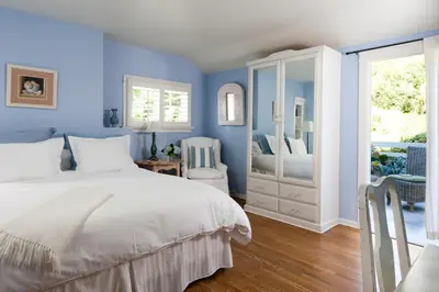 a blue bedroom with a bed and a mirror at Channel Road Inn, A Four Sisters Inn in Los Angeles