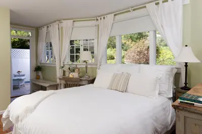 a bedroom with a white bed and windows at Channel Road Inn, A Four Sisters Inn in Los Angeles