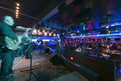 a man playing a guitar in a nightclub at Grand Vista Hotel in Simi Valley