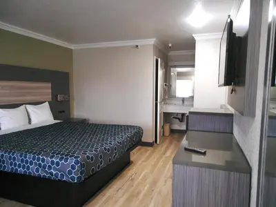 a small hotel room with a bed and a television at Americas Best Value Inn-Rialto in Rialto