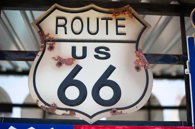 a sign that reads route us hanging on a fence at Wigwam Motel in San Bernardino