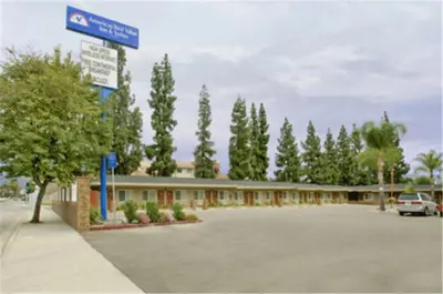 a building with a street sign in a parking lot at Americas Best Value Inn San Bernardino in San Bernardino