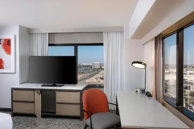 a hotel room with a tv and a desk with a chair at Hilton Los Angeles Airport in Los Angeles