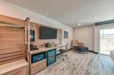 a room with a desk and a tv on a wall at Casa Via Mar Inn, an Ascend Collection Hotel in Port Hueneme