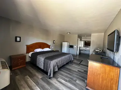 a bedroom with a bed and a flat screen tv at Sunpark Inn & Suites in San Bernardino