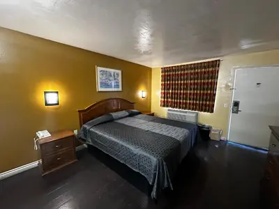 a bedroom with a large bed and a window at Sunpark Inn & Suites in San Bernardino