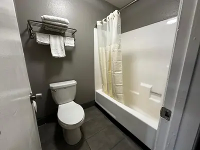 a bathroom with a toilet and a tub and a shower at Sunpark Inn & Suites in San Bernardino