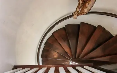 a wooden spiral staircase in a room with a mirror at The Patrician Hollywood Universal in Pasadena