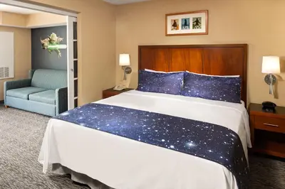 a bedroom with a large bed with stars on it at Anaheim Portofino Inn & Suites in Anaheim