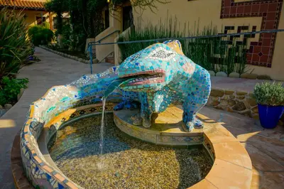 a statue of a dog drinking water from a fountain at Blue Iguana Inn in Ojai