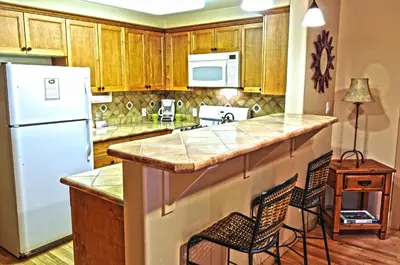 a kitchen with a white refrigerator and wooden cabinets at Blue Iguana Inn in Ojai