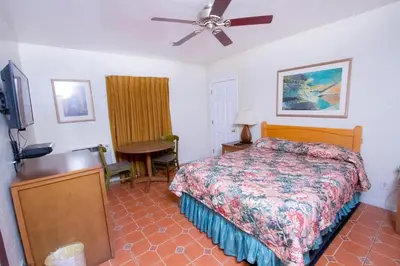 a bedroom with a bed and a flat screen tv at Mission Bell Motel in Ventura