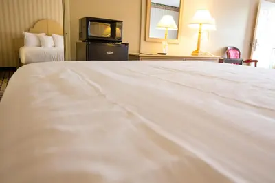 a large white bed in a hotel room at Anaheim Carriage Inn in Anaheim