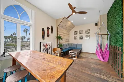 a living room with a large wooden table and chairs at Samesun Venice Beach Hotel & Hostel in Los Angeles