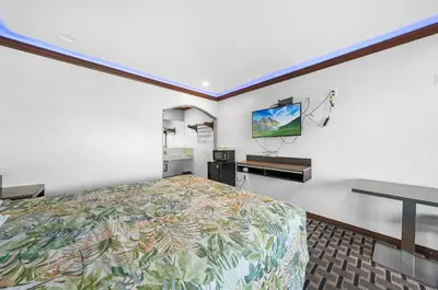 a bedroom with a bed and a flat screen tv at Starlight Inn South El Monte in South El Monte
