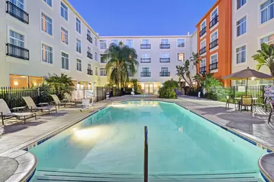 a swimming pool in the courtyard of a apartment building at Embassy Suites Valencia in Valencia