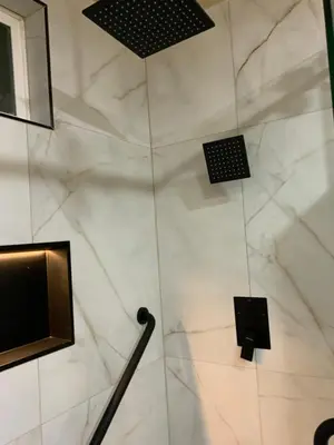 a bathroom with a white marble wall with two monitors at Beautiful Foothill Home in Rancho Cucamonga