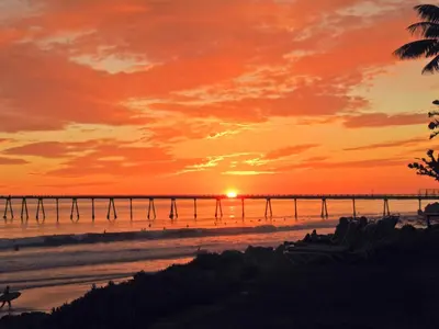 a sunset on the beach with a pier at Cliff House Inn in Carpinteria