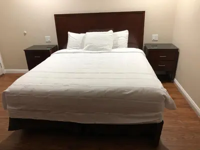 a bedroom with a large bed with two night stands at American Inn in Ontario