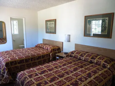 a hotel room with two beds in it at American Inn in Ontario