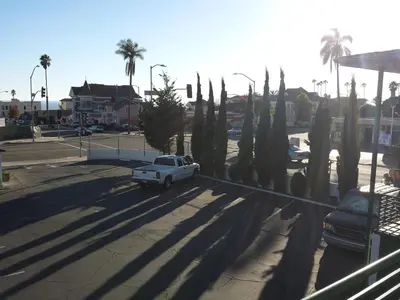 a white truck parked in a parking lot with palm trees at Travelers Beach Inn in Ventura