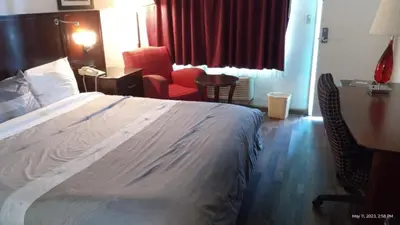 a hotel room with a bed and a desk and chairs at Travelers Beach Inn in Ventura