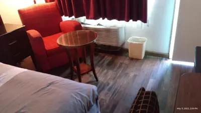 a hotel room with a table and a chair at Travelers Beach Inn in Ventura